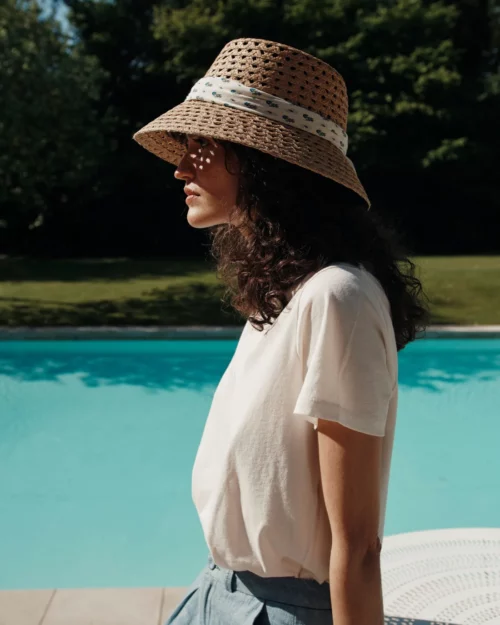 Femme de profil portant le T-Shirt Femme 100% Coton BARRY Emile et Ida crème, en extérieur au bord d’une piscine.