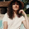 Femme portant le T-Shirt Femme 100% Coton BARRY Emile et Ida crème, assise sur une chaise blanche au bord de la piscine.