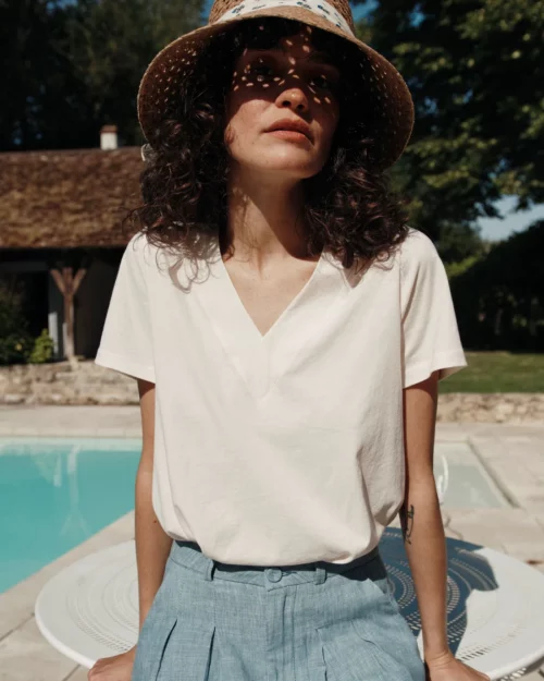 Gros plan sur une femme portant le T-Shirt Femme 100% Coton BARRY Emile et Ida crème, assise au bord de la piscine.