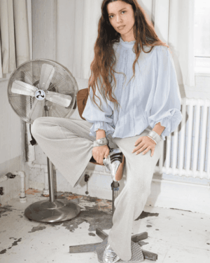 Presley blouse dusty blue. Ample. Fluide. Bleu clair. Manches longues bouffantes. Col rond.100% coton bas de manches volants,. col montant avec petit volant.