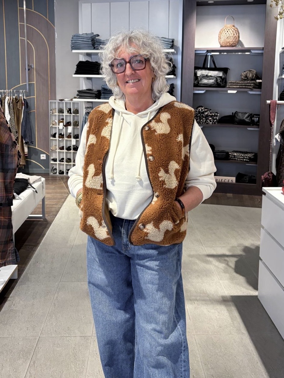 Look femme décontracté automne-hiver : gilet sherpa camel à motif écureuil Emile & Ida, sweat à capuche crème Pieces et jean large bleu Object, silhouette tendance et moderne.